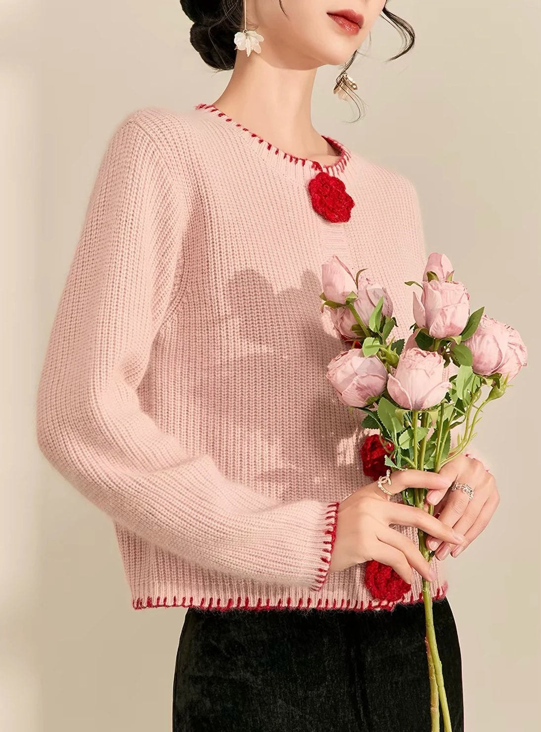 Tampak samping Rosette Cardigan dengan buket mawar pink, terlihat jahitan tepi di bagian bawah dan ujung lengan.