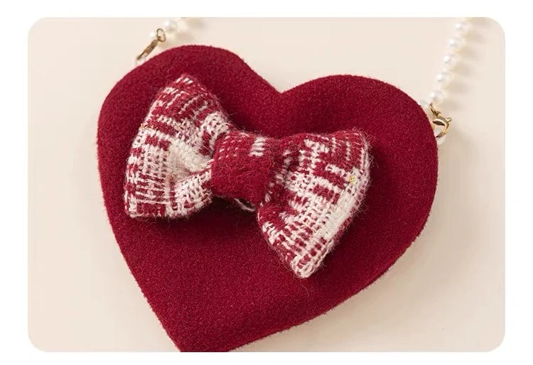 Close-up of the Delphine Dress heart mini bag, showing the burgundy and cream tweed bow at the front.