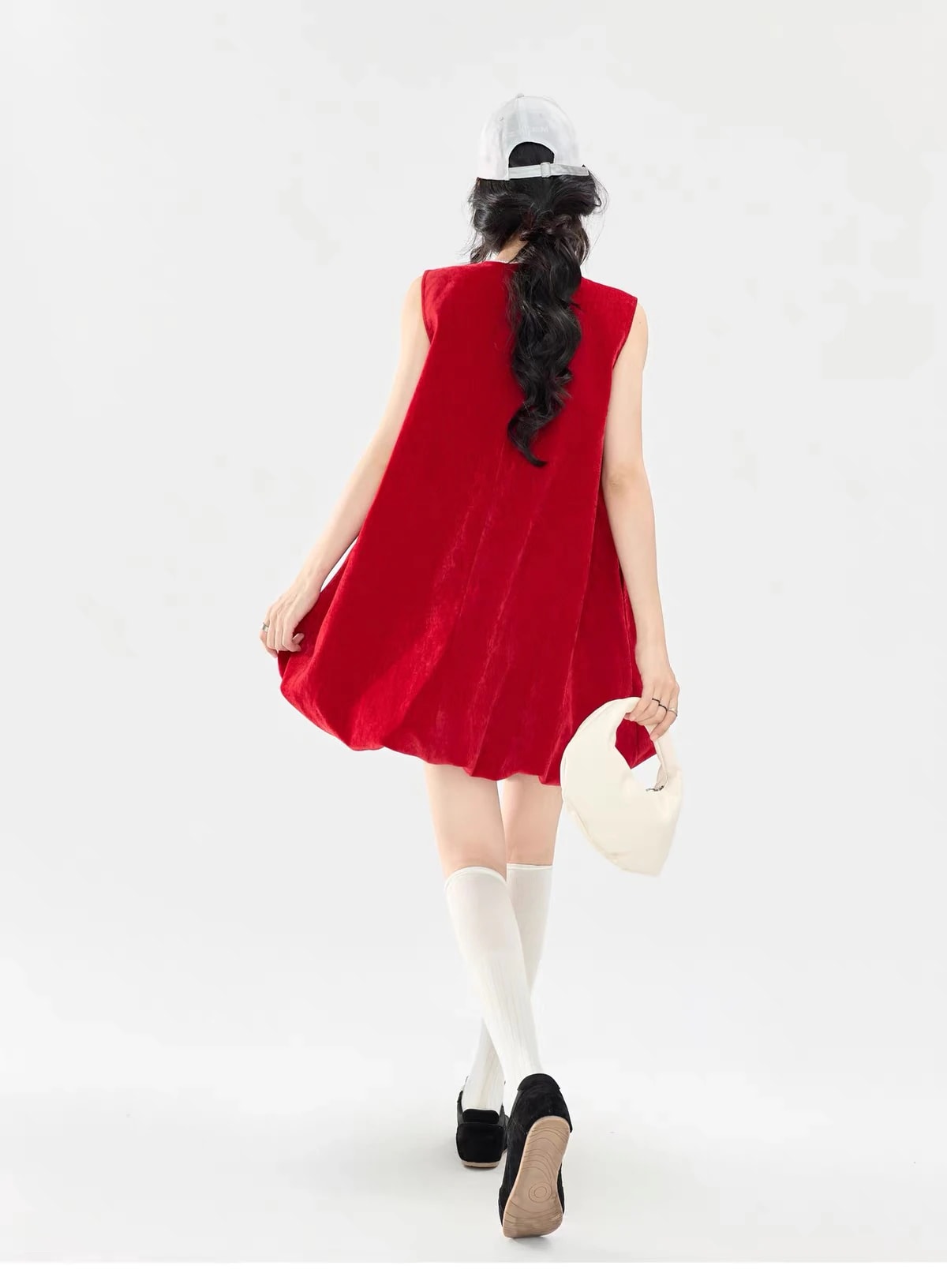 Back view of a woman walking in the Cerise Dress, showing the plain velvet back and the loose, rounded shape.