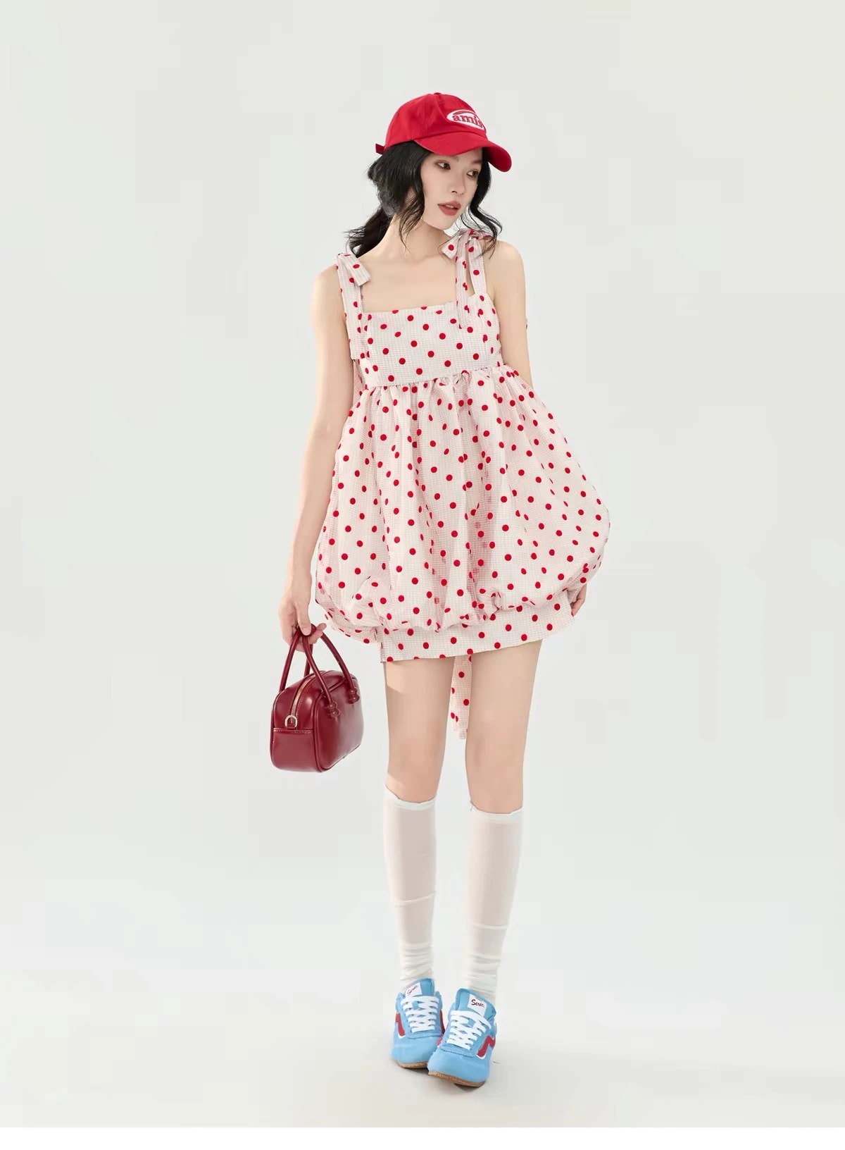 Full-length view of the Josette Dress with white knee socks, holding a red bag.