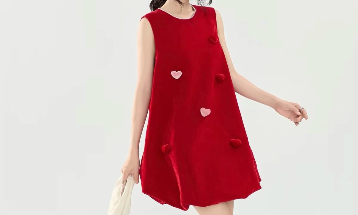 Cropped front view of a woman walking in the Cerise Dress, with red and pink velvet hearts across the front.