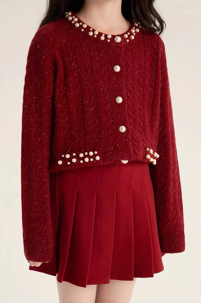 Detail bagian depan Vivienne Cardigan: rajut kepang berkilau, kancing mutiara, dan hiasan mutiara di bagian bawah.