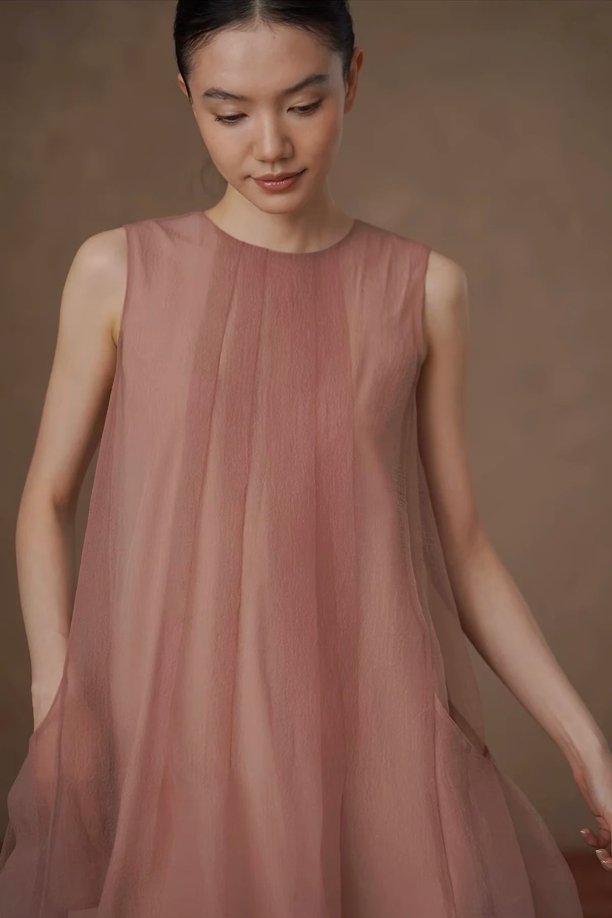Close-up of the Solene Dress round neck and soft pleats in the sheer pink gauze.
