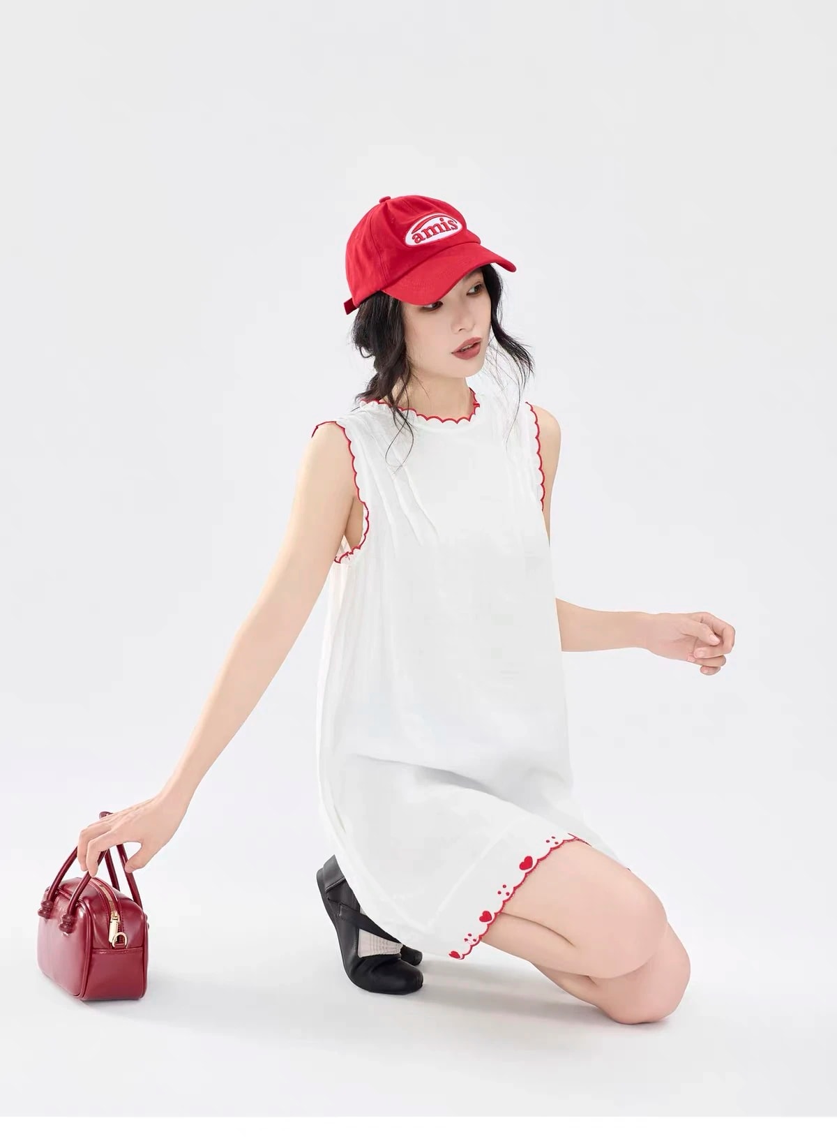 Kneeling pose in the sleeveless Lucie Dress, showing the loose cut and scalloped armholes.