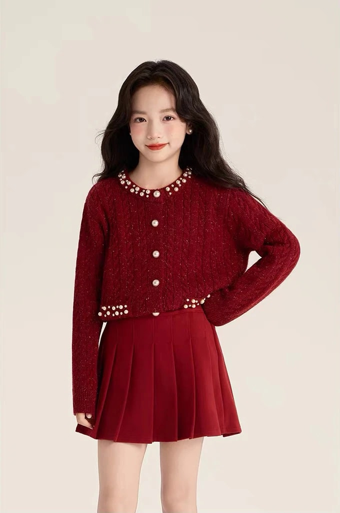 Tampak depan anak perempuan memakai Vivienne Cardigan dengan rok lipit, terlihat kerah, kancing, dan ujung bawah berhias mutiara.