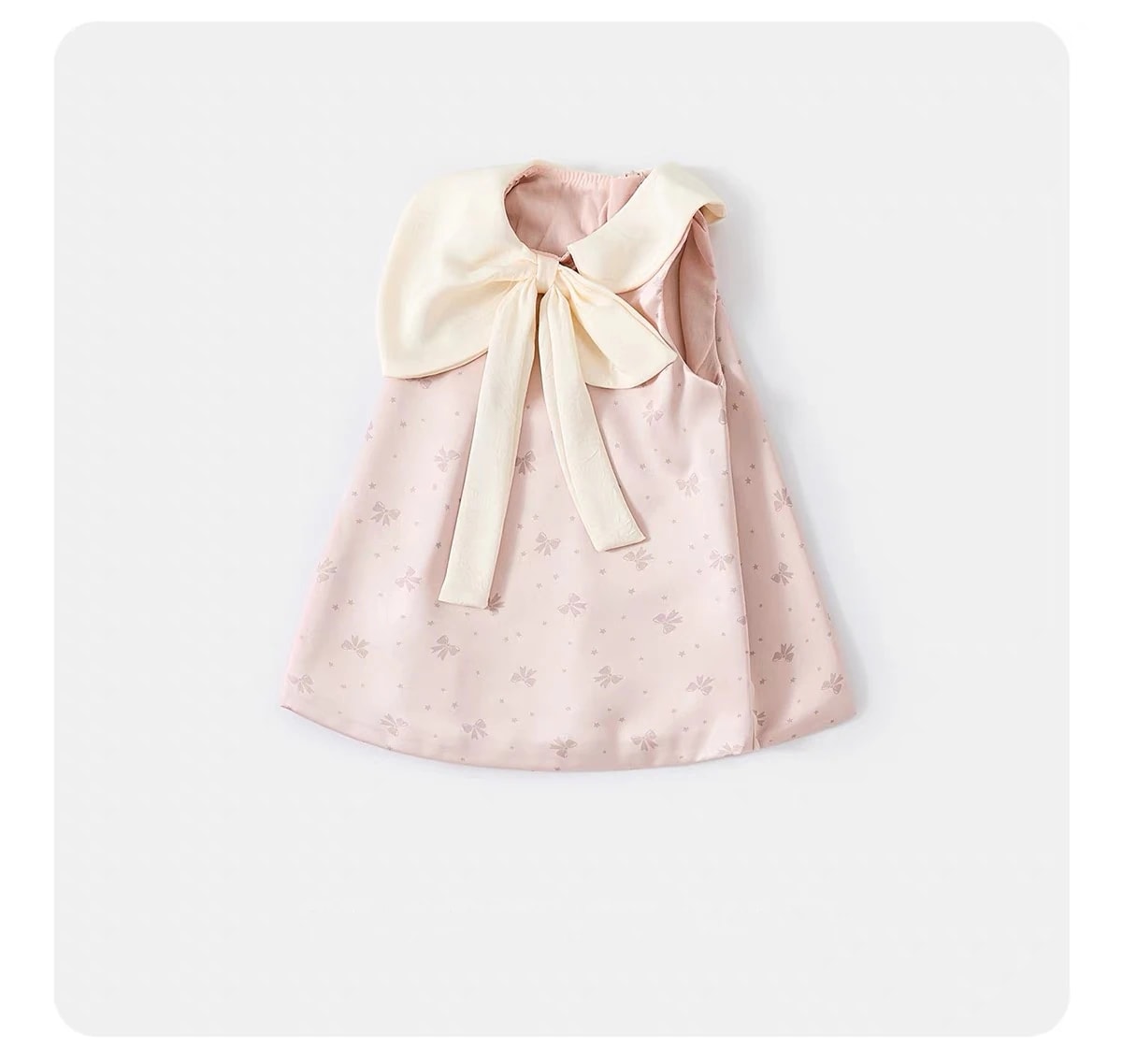 Flat lay Amelie Dress dari sudut miring, terlihat kerah gading yang menyatu menjadi pita besar.