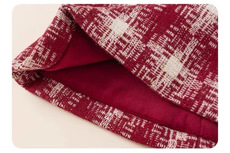 Inside view of the Delphine Dress hem, showing the textured tweed with gold flecks and the smooth burgundy lining.
